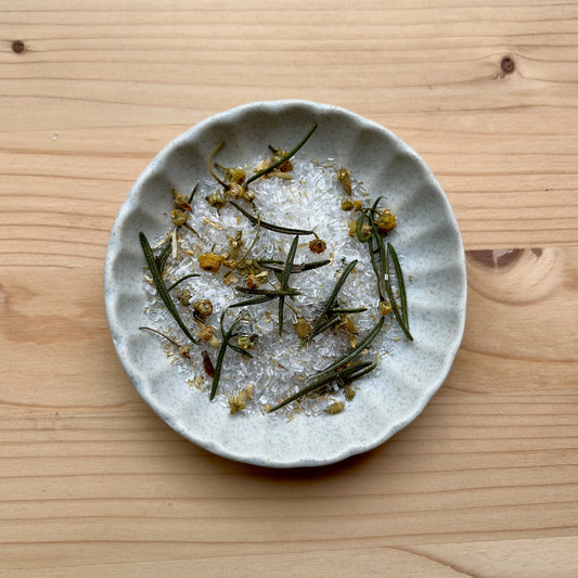 Small ceramic plate with dried herbs on a wooden surface
