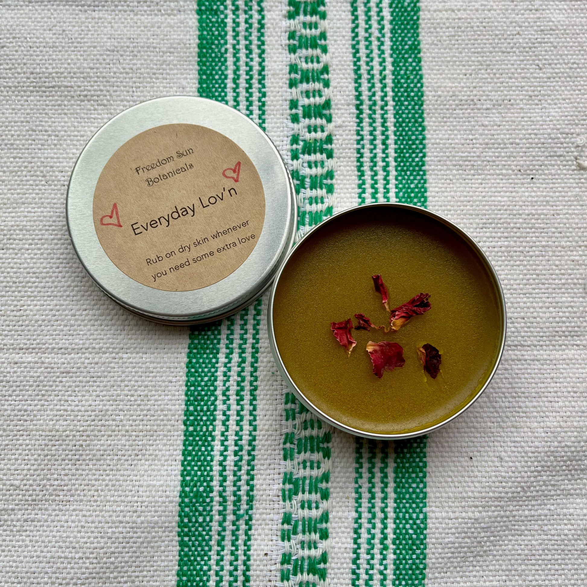 Small container with lid on a textured surface with green and white stripes