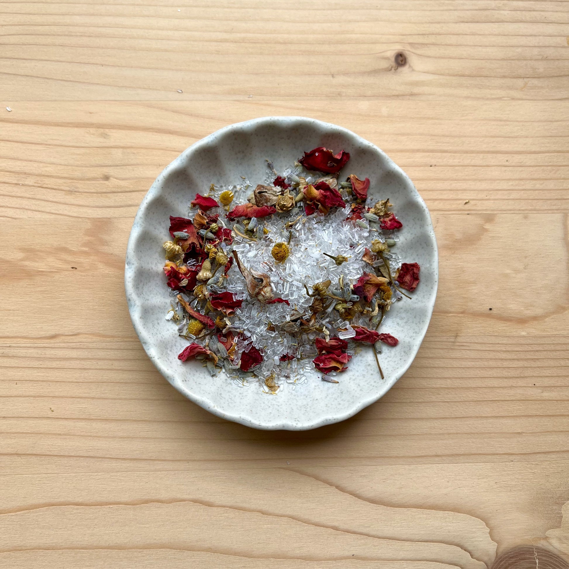 Small plate with dried herbs and spices on a wooden surface