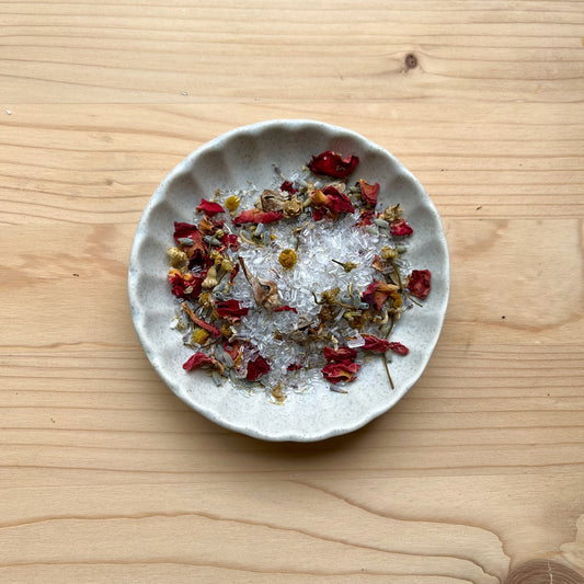 Small plate with dried herbs and spices on a wooden surface