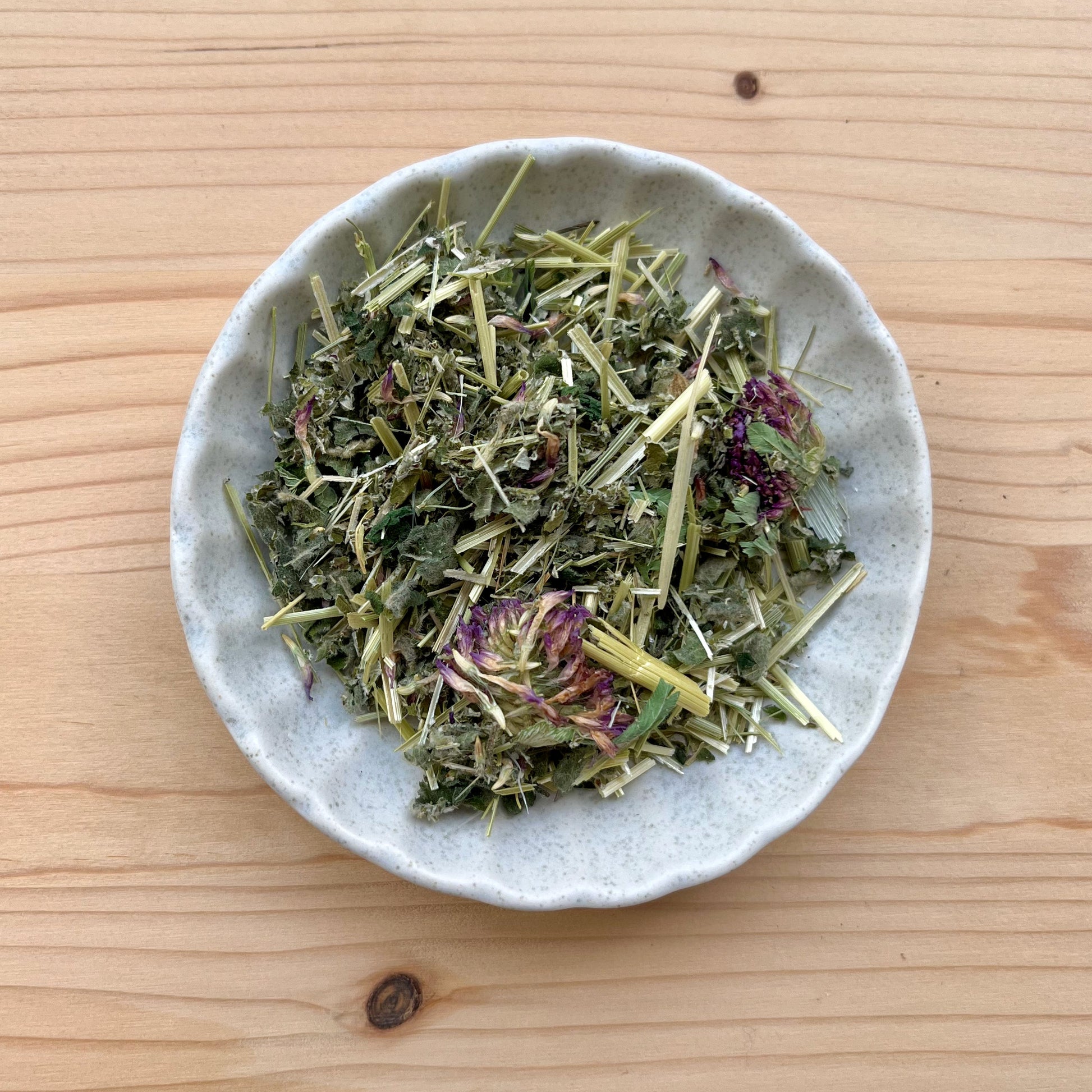 loose tea on white plate on wooden background