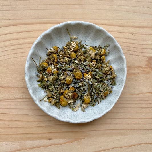 Small bowl of dried herbs on a wooden surface